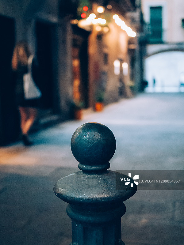 街上的铸铁护柱，背景是一位年轻女子图片素材