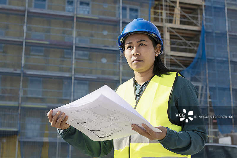 女人在建筑工地拿着蓝图图片素材