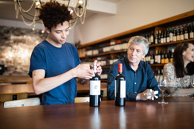 侍酒师在品酒会上打开一瓶葡萄酒图片素材