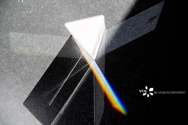 黑色纸上的玻璃三角棱镜和光学棱镜图片素材