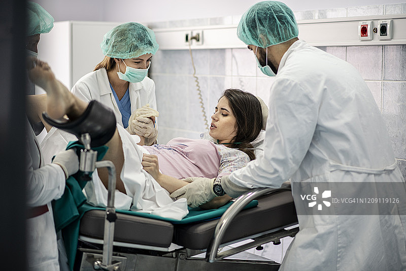 在医院里，妇女分娩时得到支持，产科医生协助。现代化的分娩病房配有专业的助产士图片素材