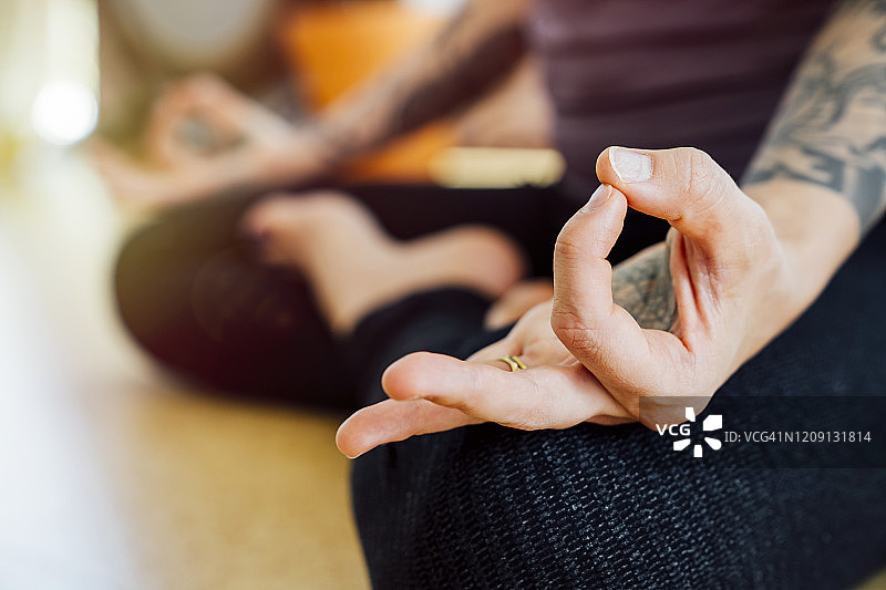 女人练习瑜伽，手持智慧手印特写图片素材