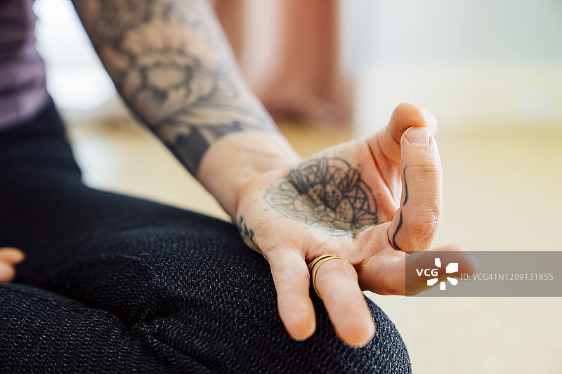 女人练习瑜伽，手持智慧手印特写图片素材