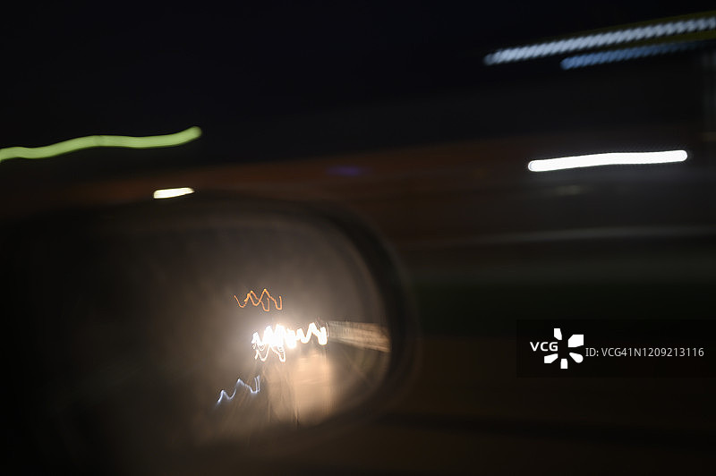 在夜间行驶的汽车的后视镜图片素材