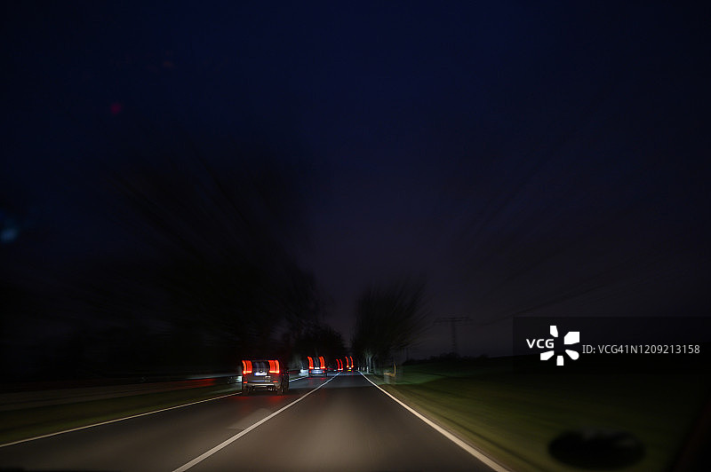 夜间在高速公路上行驶的汽车，图像模糊代表运动和速度感图片素材