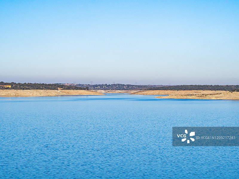 拉阿尔门德拉水库平静水面与清澈天空的壮丽景色图片素材