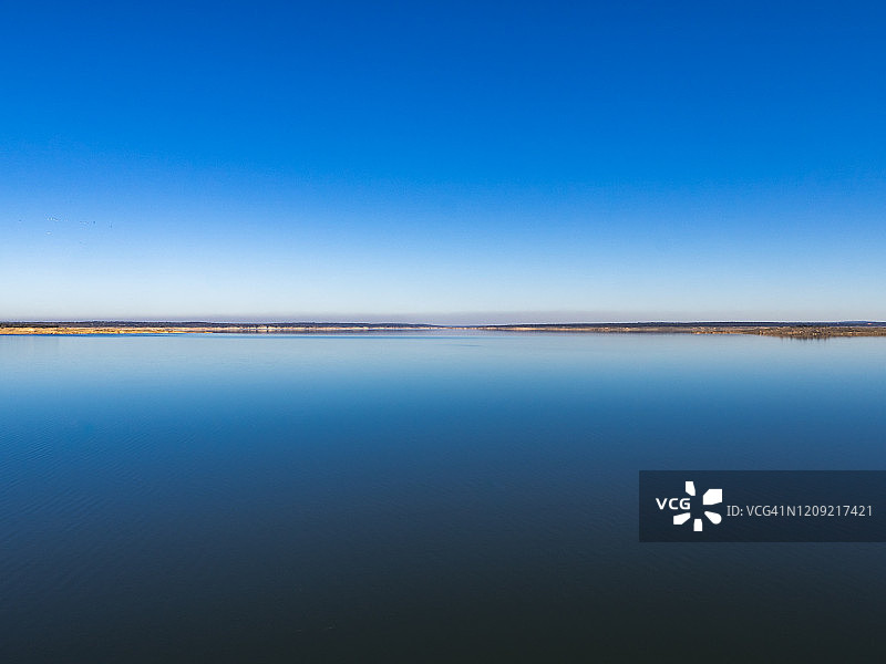 拉阿尔门德拉水库平静水面与清澈天空的壮丽景色图片素材
