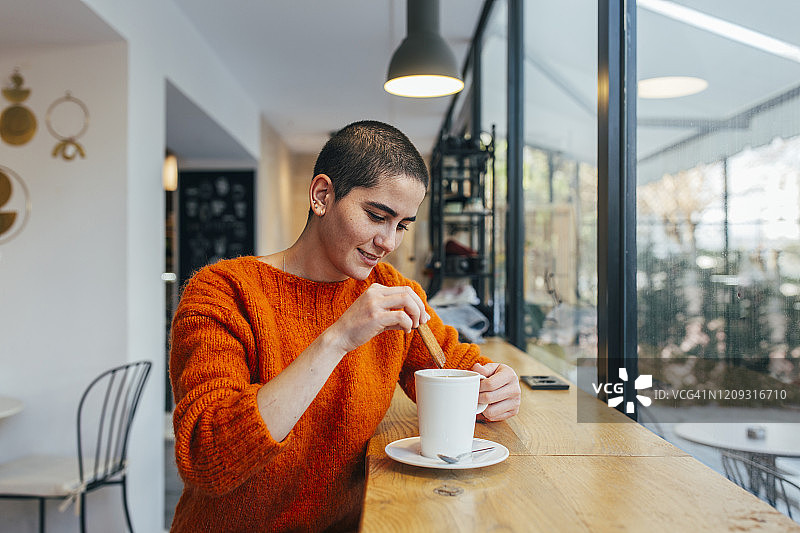 微笑的平静年轻女人喝咖啡图片素材