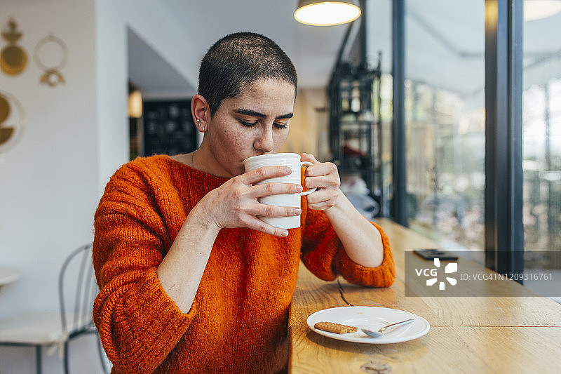 微笑的平静年轻女人喝咖啡图片素材