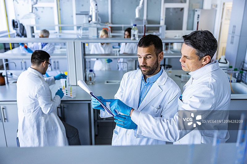 男专家在实验室合作研究医疗数据图片素材