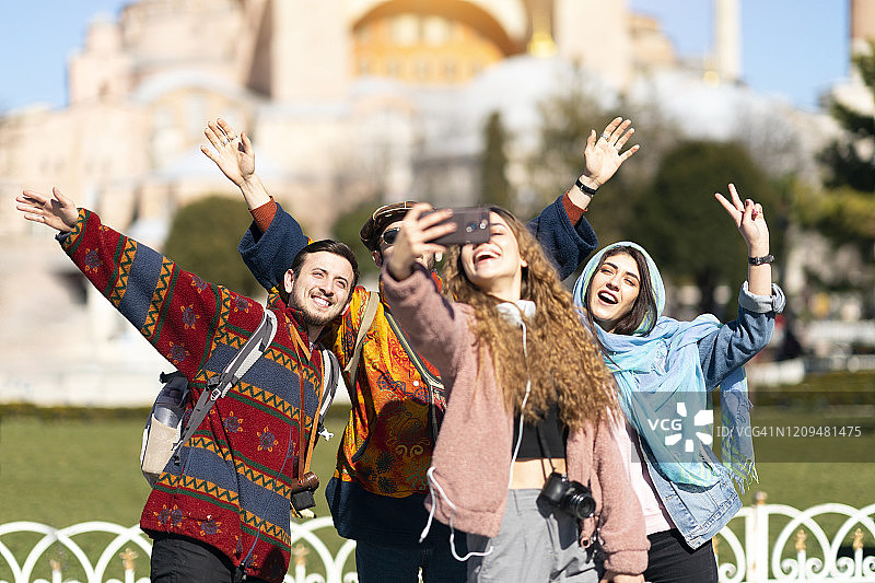 在伊斯坦布尔圣索菲亚大教堂前自拍的年轻人图片素材