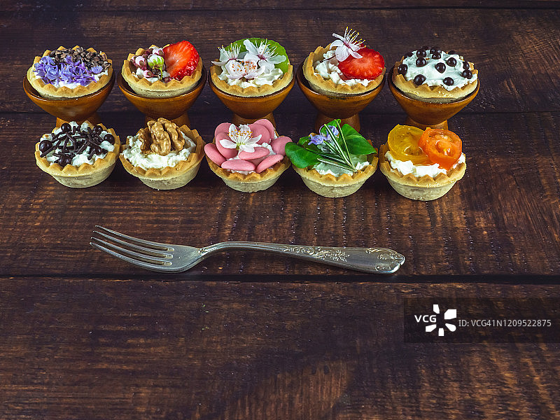 带食用鲜花的甜咸小吃和木桌上的旧羊驼叉子图片素材