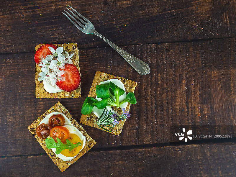 带食用鲜花的甜咸小吃和木桌上的旧羊驼叉子图片素材