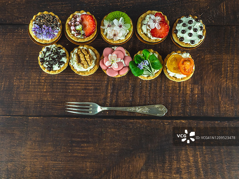 带食用鲜花的甜咸小吃和木桌上的旧羊驼叉子图片素材