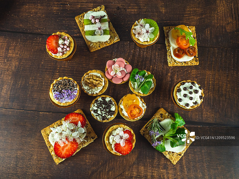 木桌上的甜咸小点心配可食用鲜花图片素材