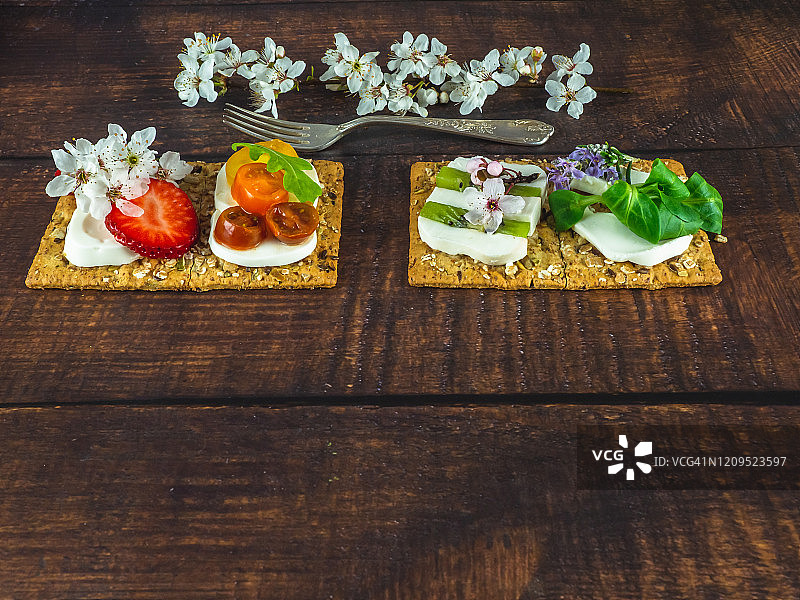 带食用鲜花的甜咸小吃和木桌上的旧羊驼叉子图片素材