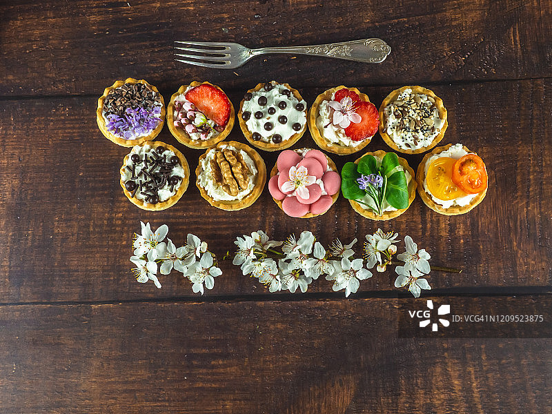 带食用鲜花的甜咸小吃和木桌上的旧羊驼叉子图片素材