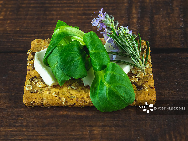 自制小吃：斯佩尔特饼干和奶酪，配以新鲜奶酪、芝麻菜和迷迭香图片素材