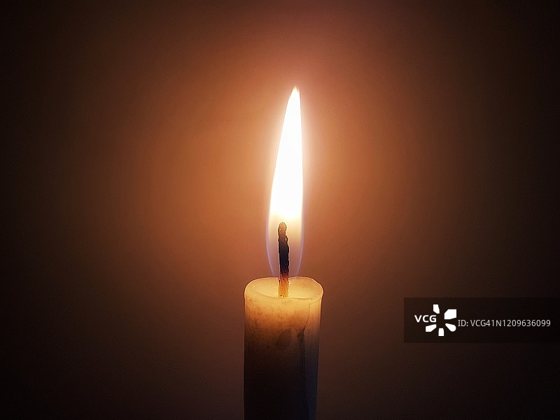 深色背景前点亮的蜡烛特写图片素材