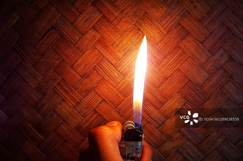 手持打火机对着编织背景图片素材