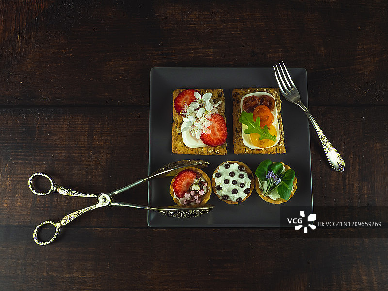 甜味和咸味小点心，方形盘子，木桌图片素材