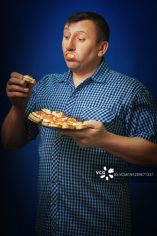 饥饿的人的肖像。强烈的食欲。期待美味的午餐。国民美食三明治。对食物的依赖。图片素材