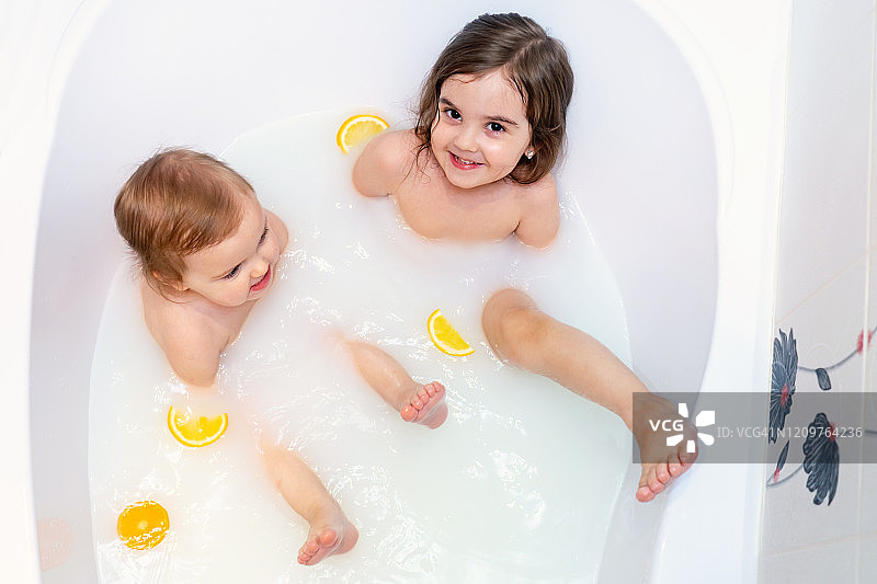 女婴用橙子洗牛奶浴图片素材