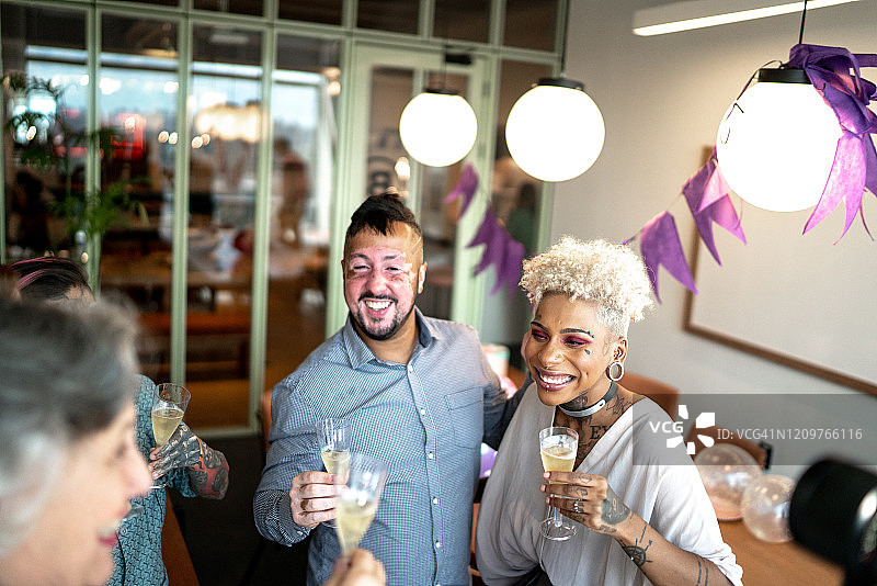 在办公室生日派对上举杯庆祝的商务人士图片素材