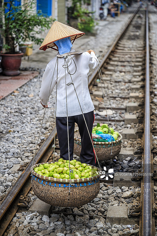 越南妇女在河内老城区出售热带水果图片素材