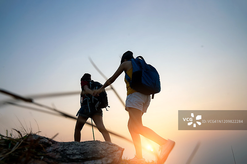 两位年轻的亚洲时尚女性在山区度假徒步旅行，进行野外探险，旅行概念背景。图片素材