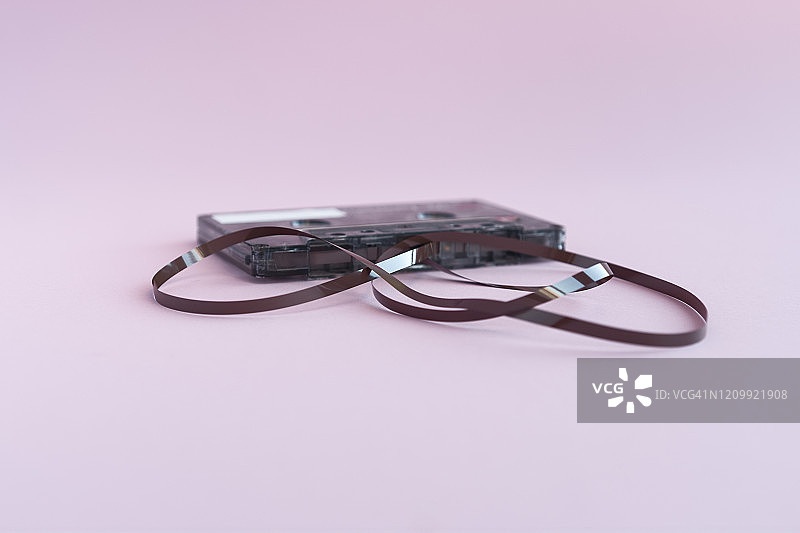 粉色背景上的散带单盒录音带图片素材