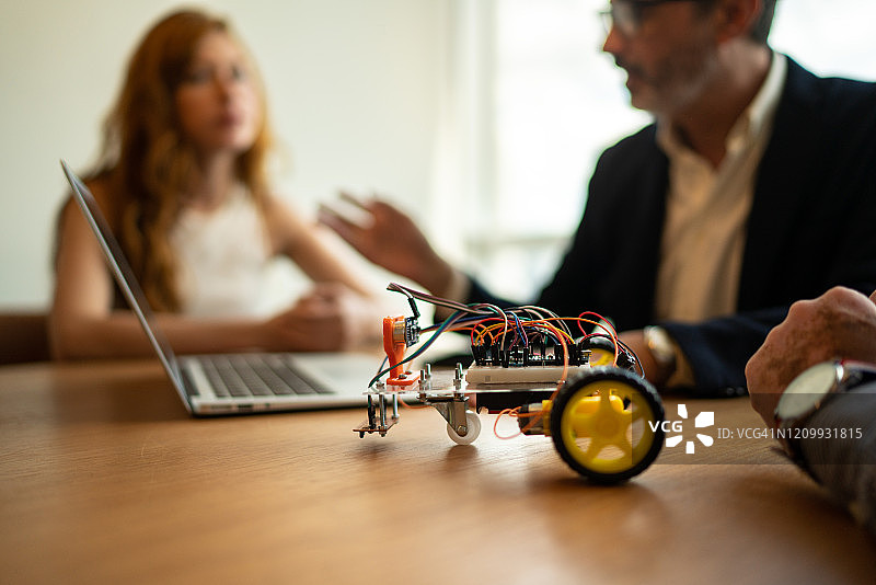 商务伙伴致力于驱动机器人汽车的原型图片素材