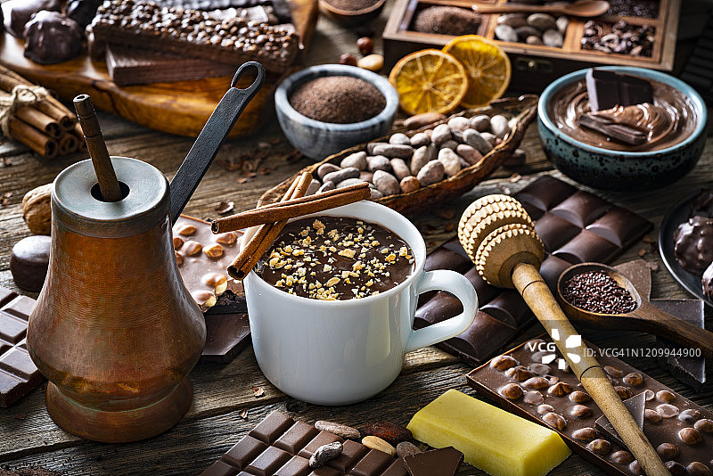 融化的巧克力杯与复古铜制巧克力壶图片素材