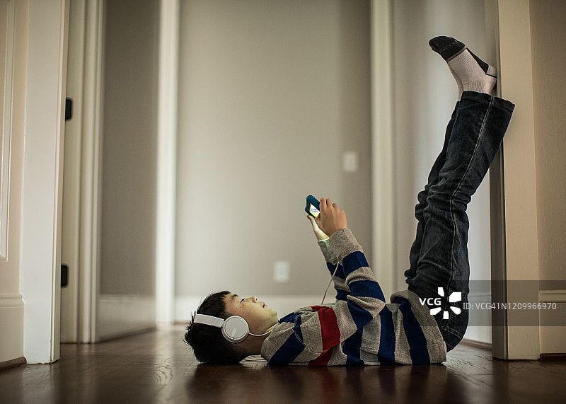 小男孩在家使用数位板和耳机图片素材