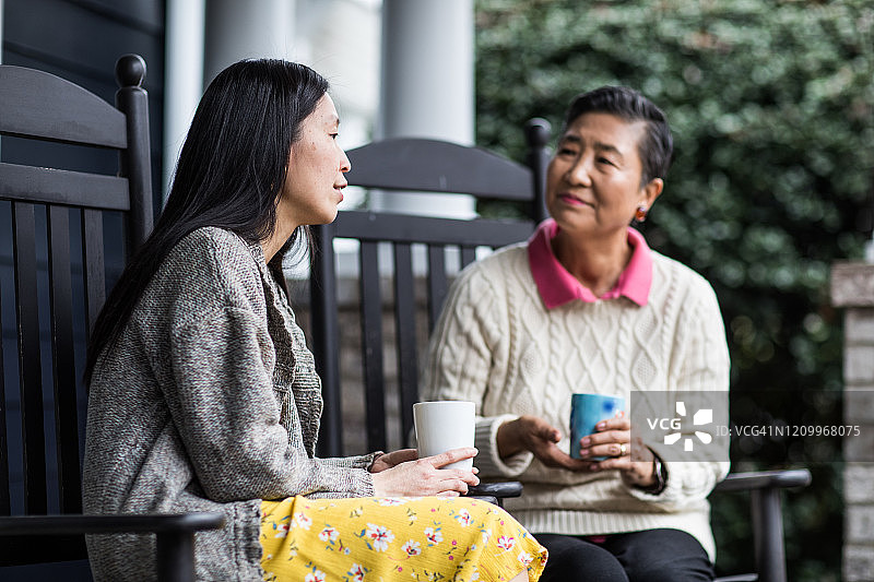 成年女子和年迈的母亲在前廊聊天图片素材