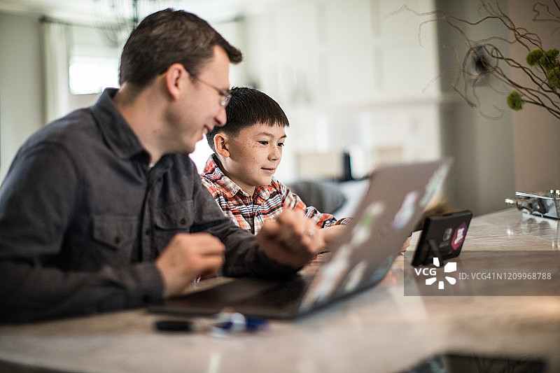 父子在家使用数位板和笔记本电脑图片素材