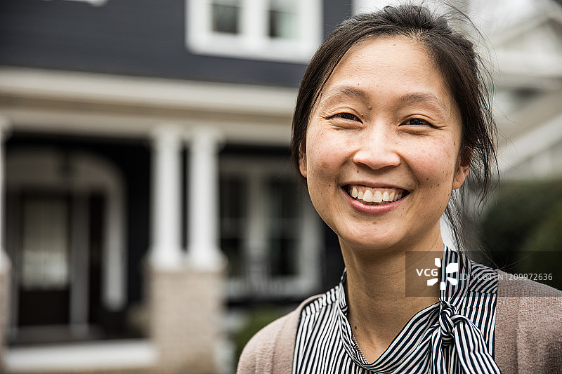 在房子前微笑的女人肖像图片素材