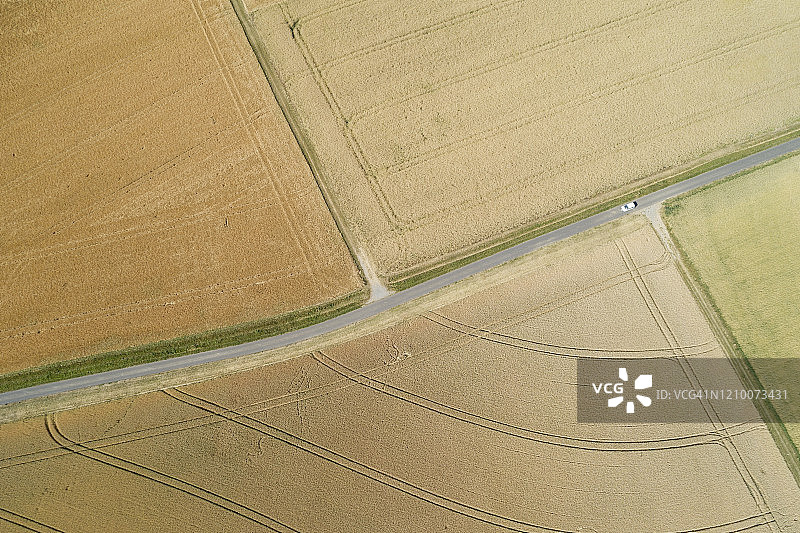 乡村景观中乡村公路和土路（轮胎痕迹）与公路交叉口的鸟瞰图图片素材