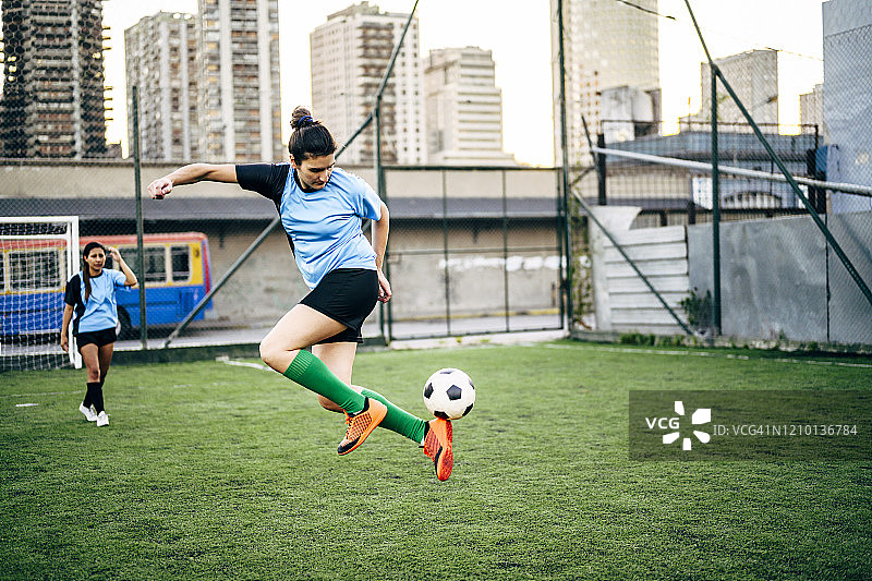 控制球的敏捷年轻西班牙裔女足球运动员图片素材