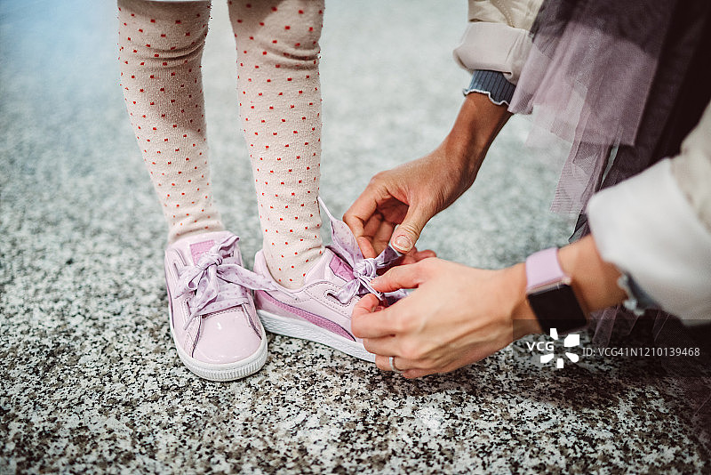 妈妈帮小女孩系鞋带图片素材