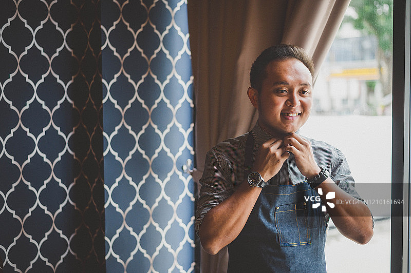 站在咖啡馆的亚洲男咖啡师图片素材