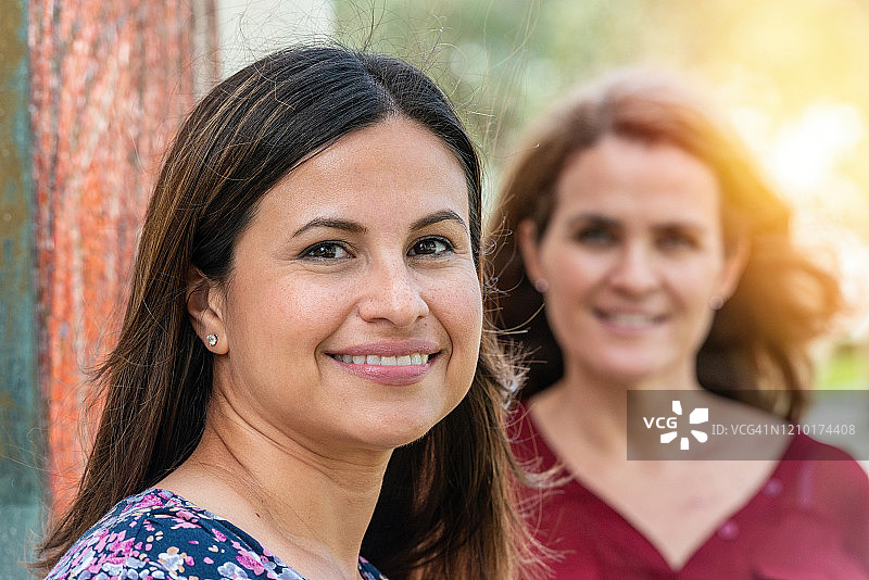 微笑的年长西班牙裔女子与朋友合影图片素材