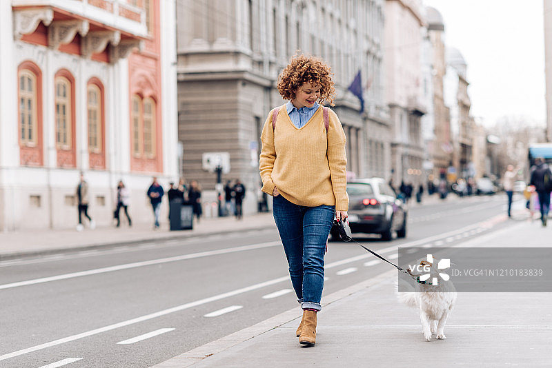 女孩遛狗并享受乐趣图片素材