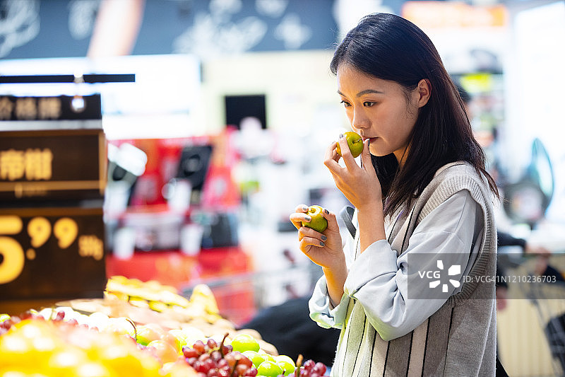年轻女子在超市购买水果图片素材