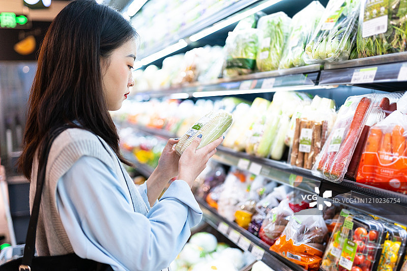 年轻女子在超市购买蔬菜图片素材