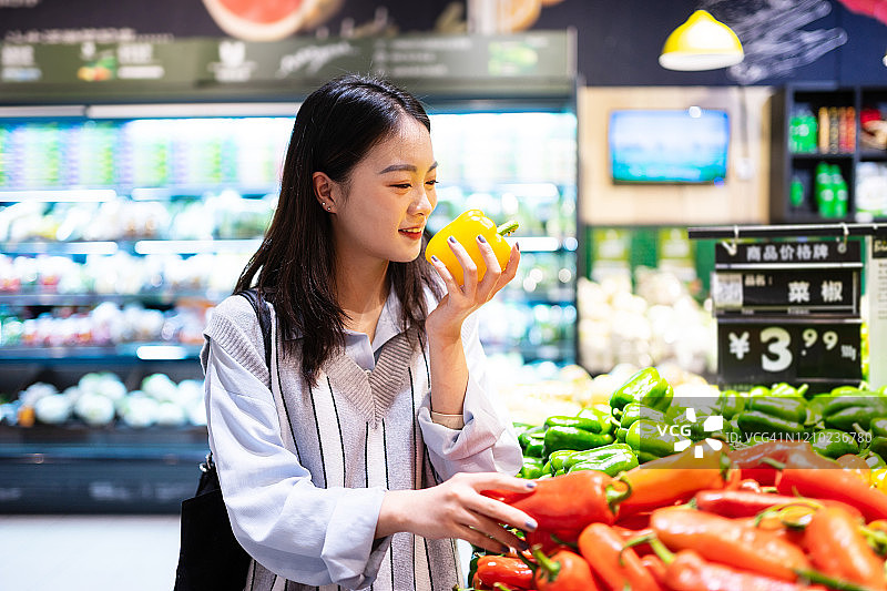 年轻女子在超市购买蔬菜图片素材