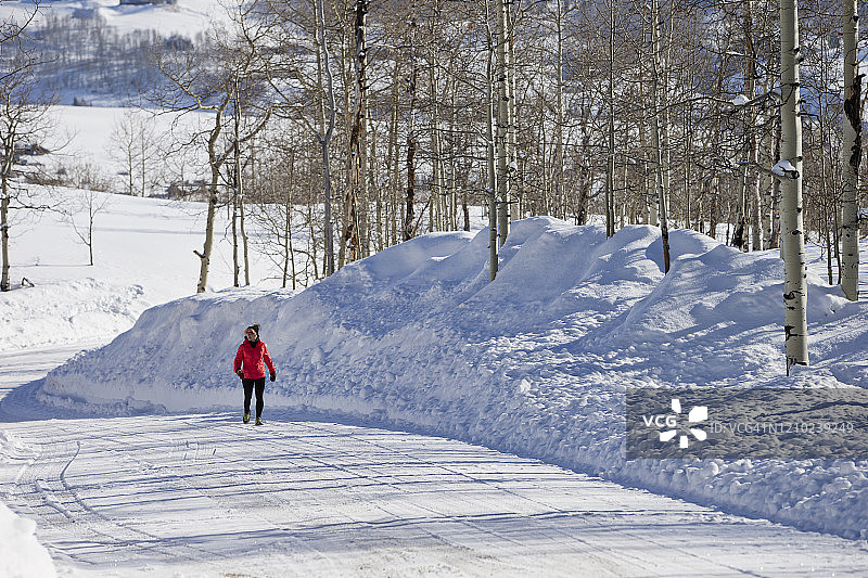 在雪路上行走的女人图片素材
