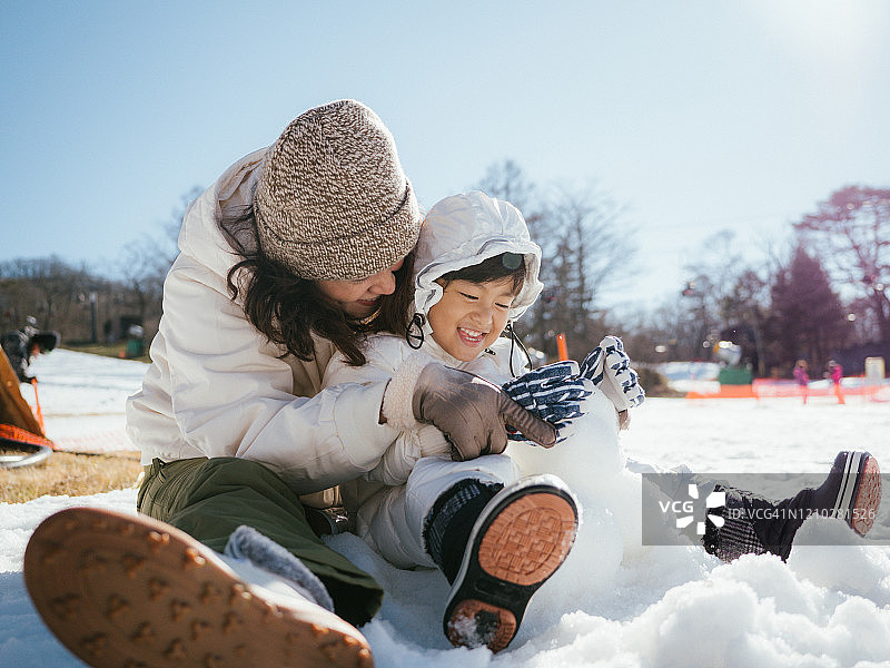 女游客和孩子在雪地里玩耍图片素材