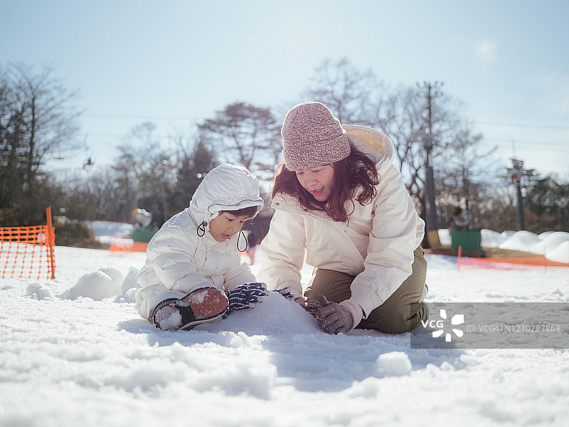 女游客和孩子在雪地里玩耍图片素材