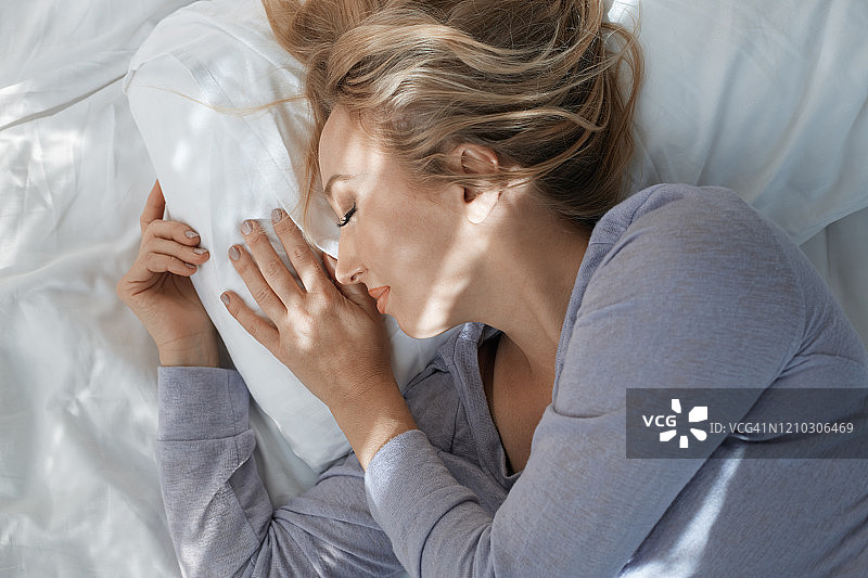 清晨熟睡的漂亮金发女人图片素材